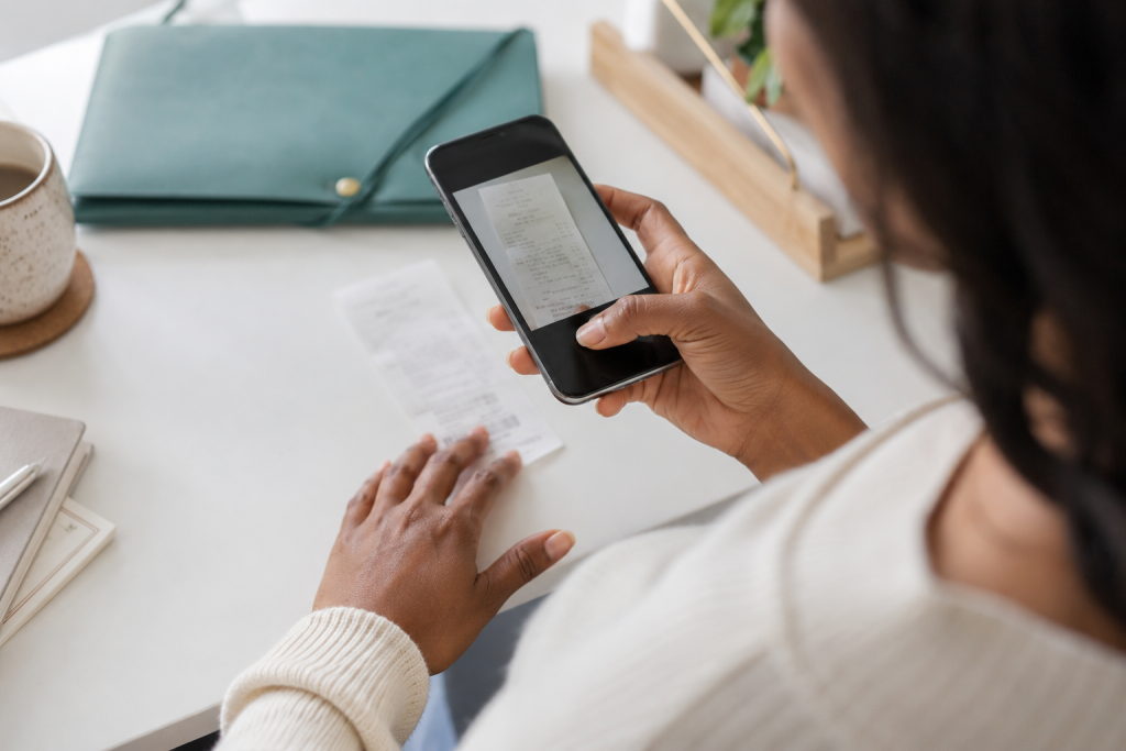 Freelancer photographing a business receipt with a smartphone.